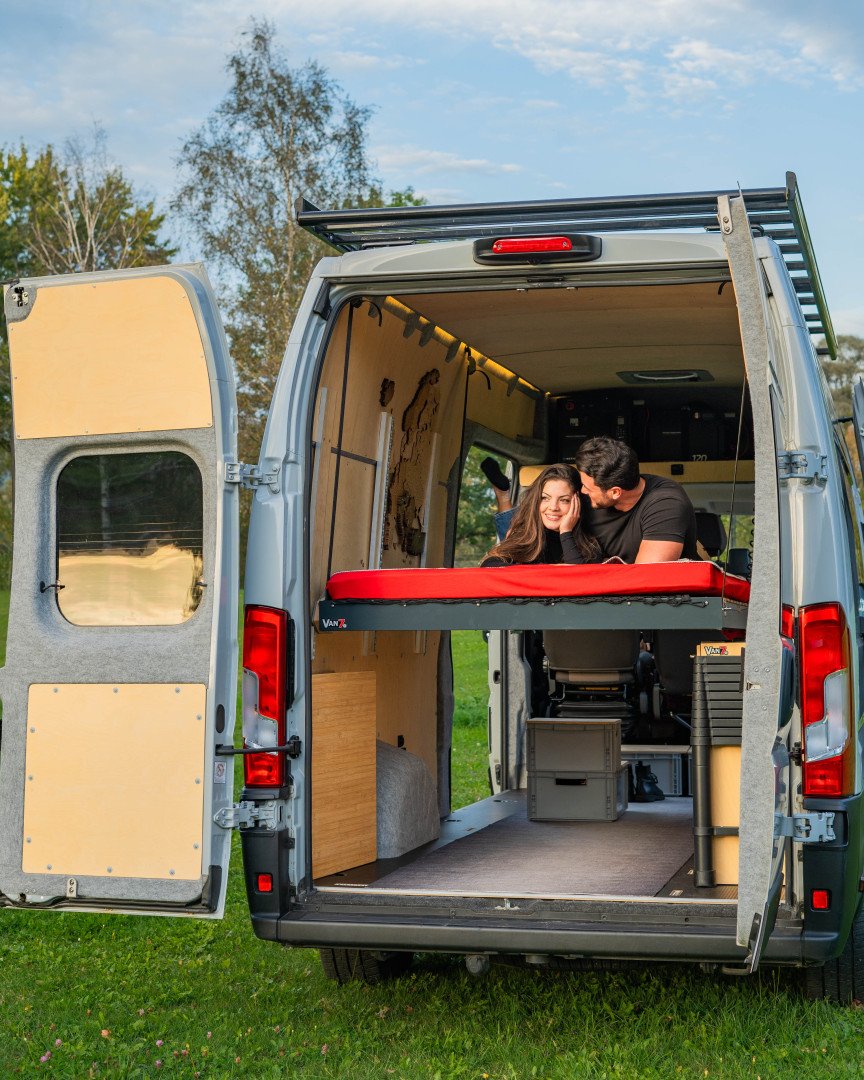 Ein Paar liegt im Hubbett eines Vans